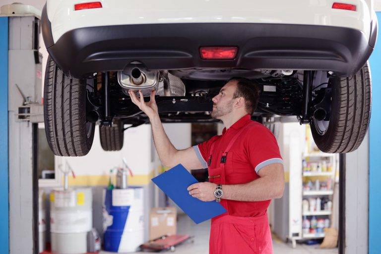 Man inspecting car exhaust